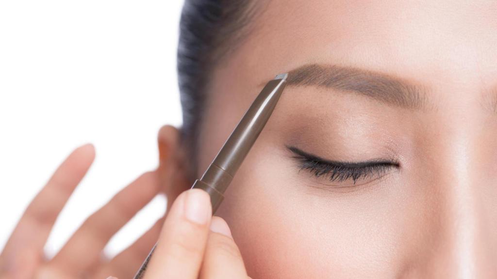 Imagen de una mujer maquillándose las cejas.