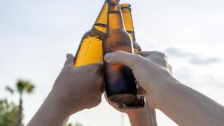 Varios jóvenes sostienen botellines de cerveza, en una imagen de archivo.