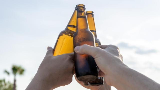 Varios jóvenes sostienen botellines de cerveza, en una imagen de archivo.