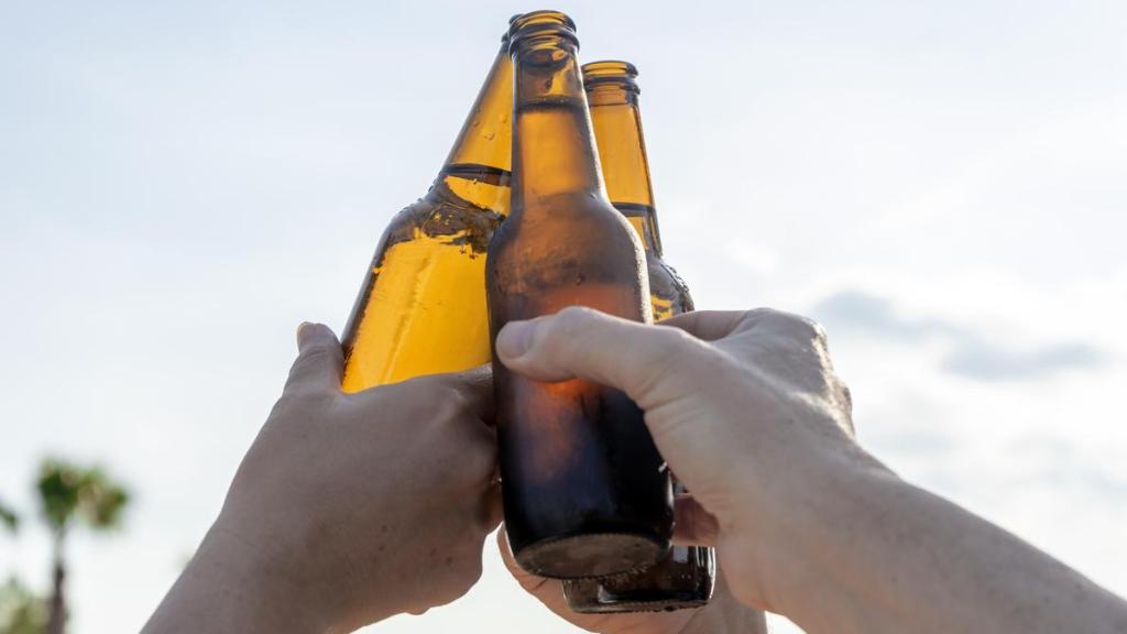 Varios jóvenes sostienen botellines de cerveza, en una imagen de archivo.