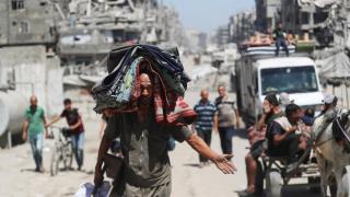 Palestinos desplazados se abren paso mientras huyen en medio de una operación militar israelí, en la ciudad de Gaza.