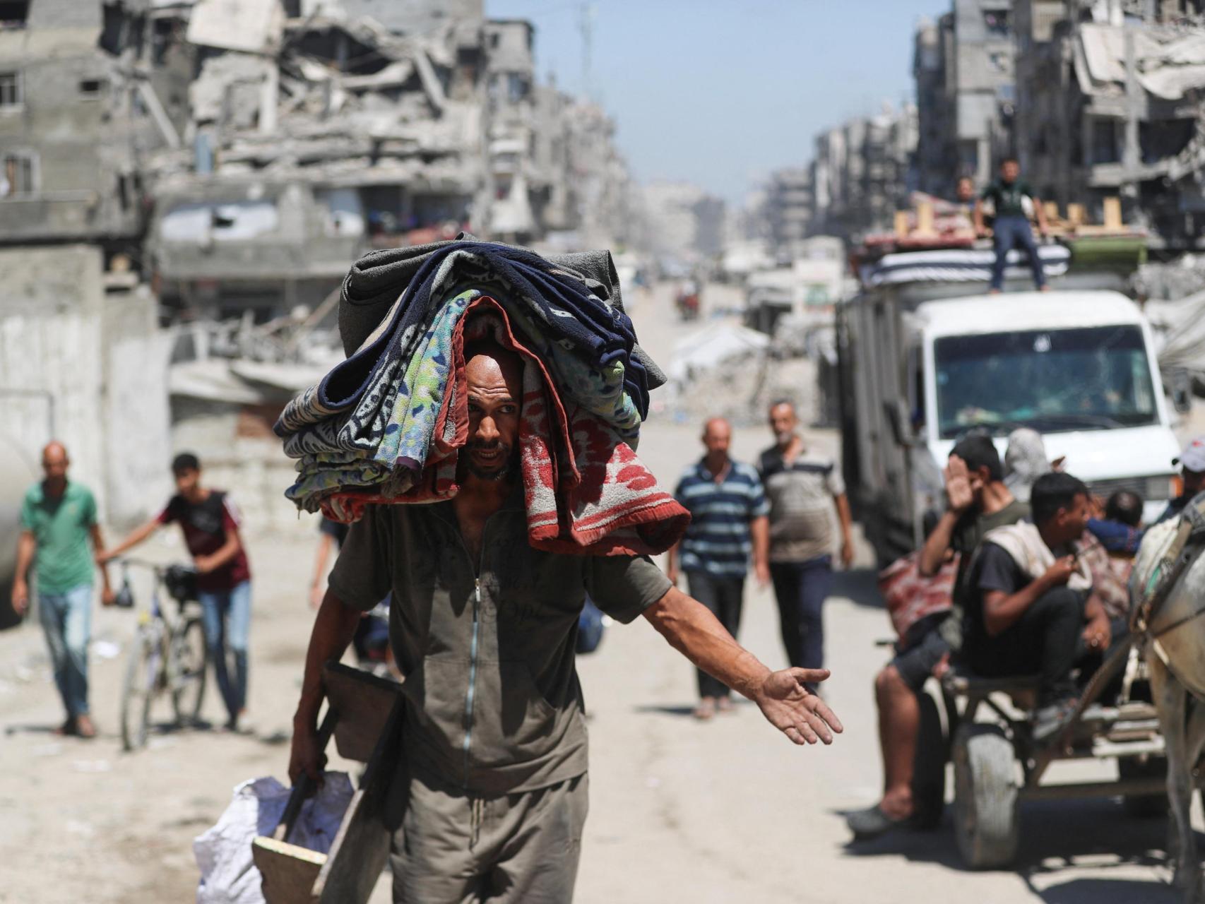 Palestinos desplazados se abren paso mientras huyen en medio de una operación militar israelí, en la ciudad de Gaza.