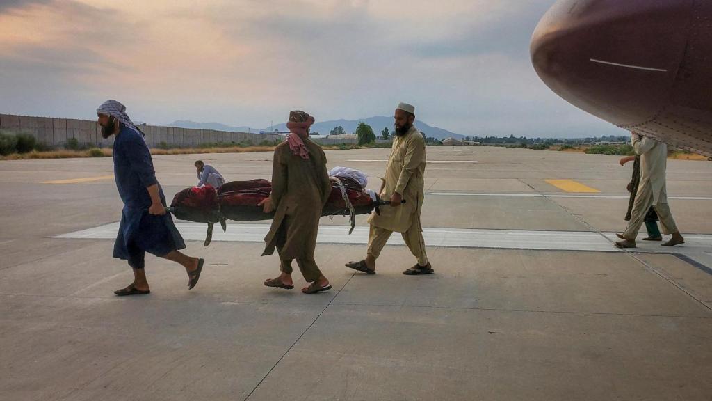 Personas trasladan en una camilla a una víctima del terremoto hacia una ambulancia en un aeropuerto de Jalalabad, Afganistán, el 1 de septiembre de 2025.