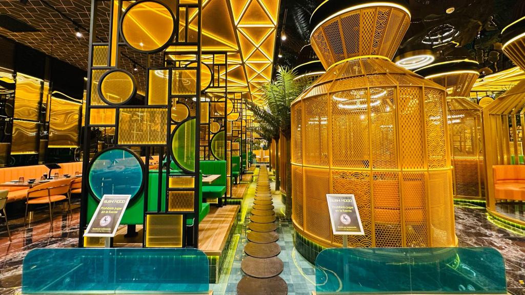 Mesas del buffet recubiertas en jaulas doradas sobre el agua.