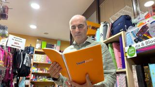 Fernando Rodríguez, miembro de la directiva de la Librería Ambrosio Rodríguez, observando uno de los cuadernos