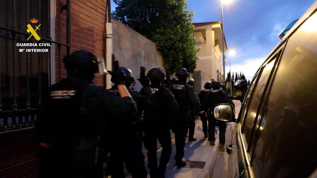 Los agentes entrando en una de las viviendas para realizar el registro