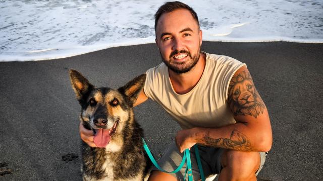 Samuel León, educador canino, con su perro en la playa.