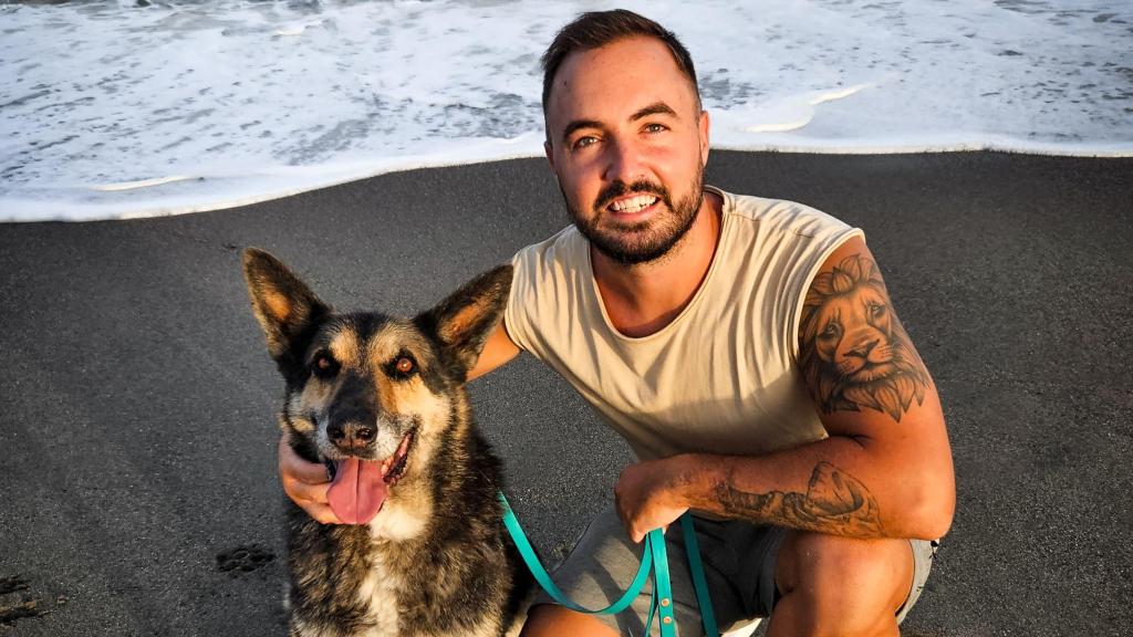 Samuel León, educador canino, con su perro en la playa.