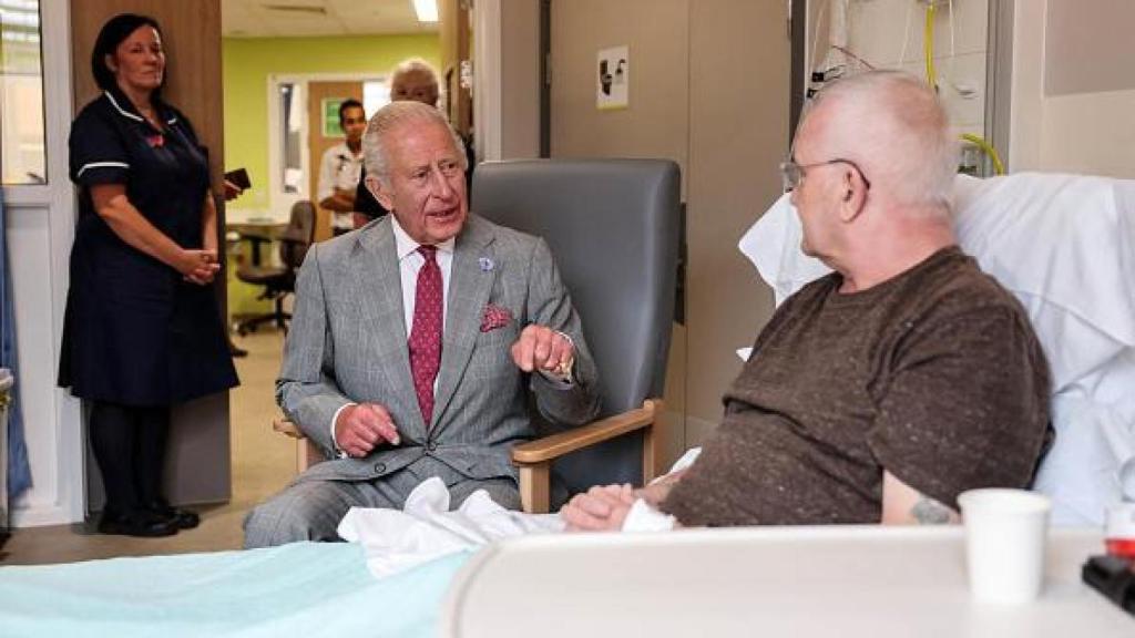 Carlos III de Inglaterra hablando con un paciente de oncología.