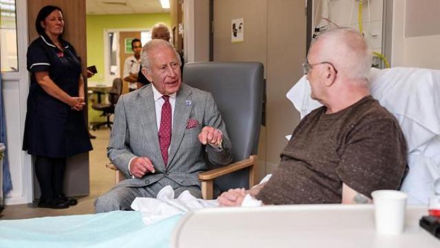 Carlos III de Inglaterra hablando con un paciente de oncología.