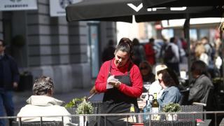 Imagen de archivo de una camarera atendiendo a unos clientes
