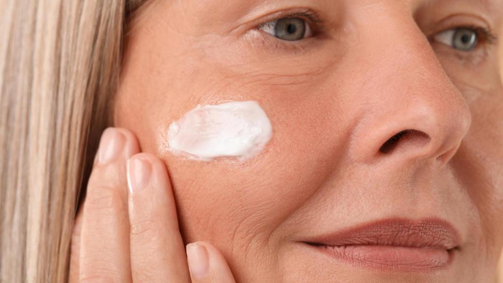 Imagen de una mujer aplicándose crema en el rostro.
