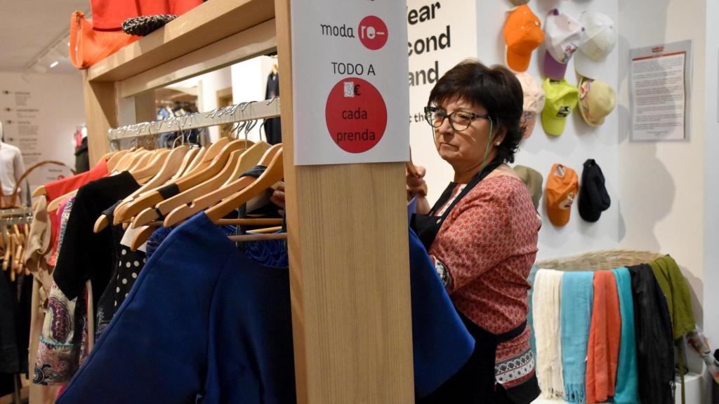 Lidia coloca algunas prendas en la tienda de Moda RE-