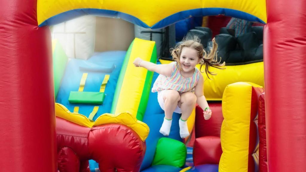 Una niña salta en una atracción hinchable.