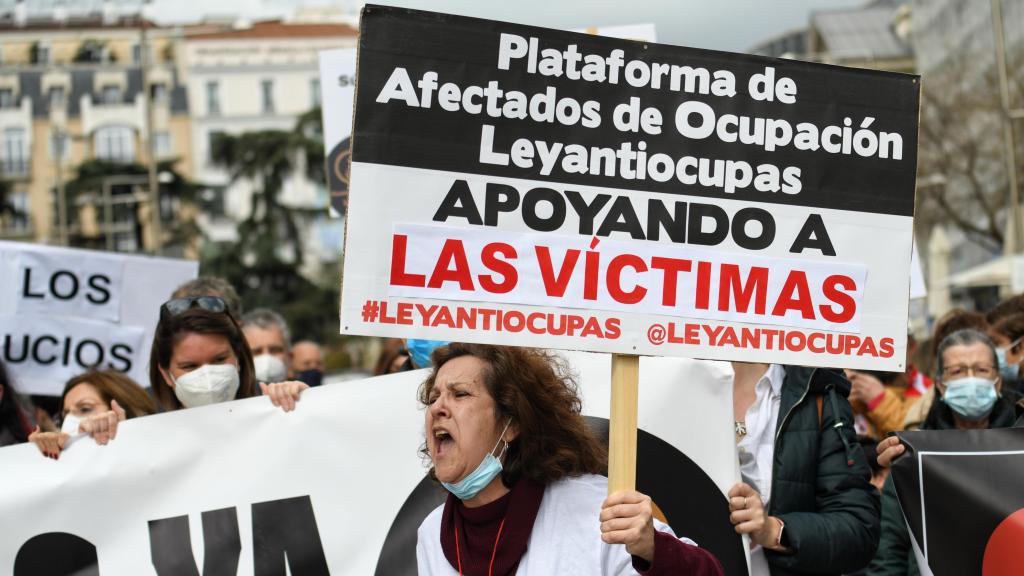 Señora manifestándose con una pancarta de la Plataforma Afectados Ocupación.