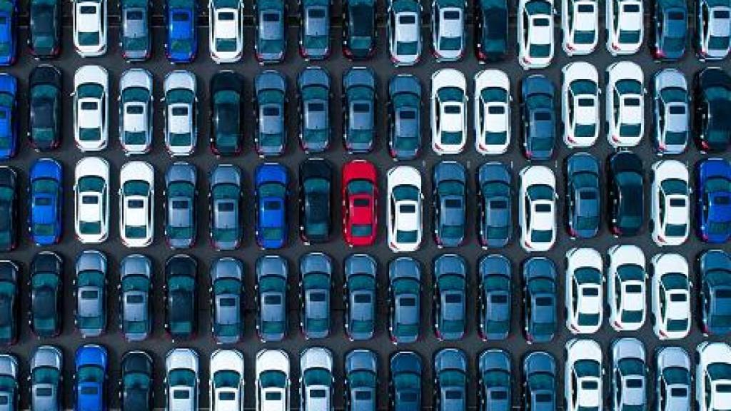 Imagen de un gran número de vehículos en un parking.