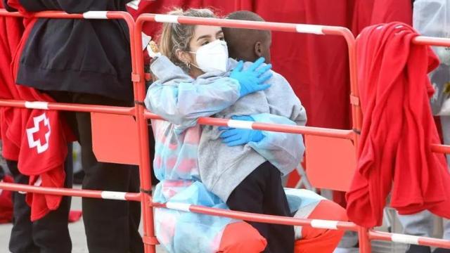 Una voluntaria de Cruz Roja abraza a un menor llegado en patera, en Puerto del Rosario (Las Palmas).