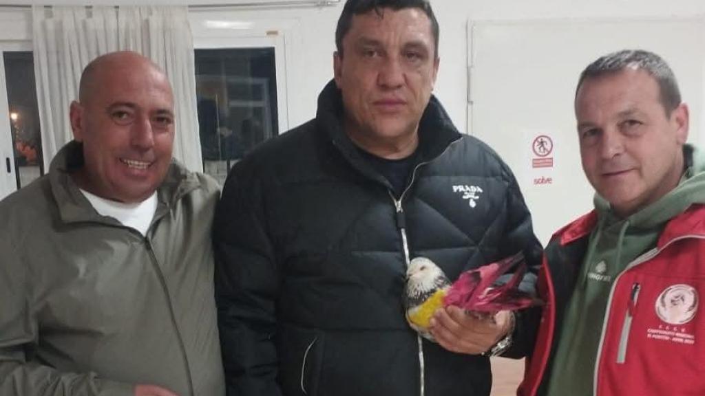 Pedro Alarcón (izquierda) y otros dos propietarios de los palomos, posando con Sordo.