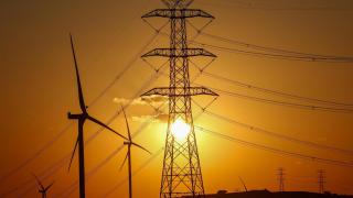 Un parque eólico y torres eléctricas.