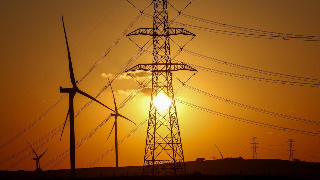 Un parque eólico y torres eléctricas.