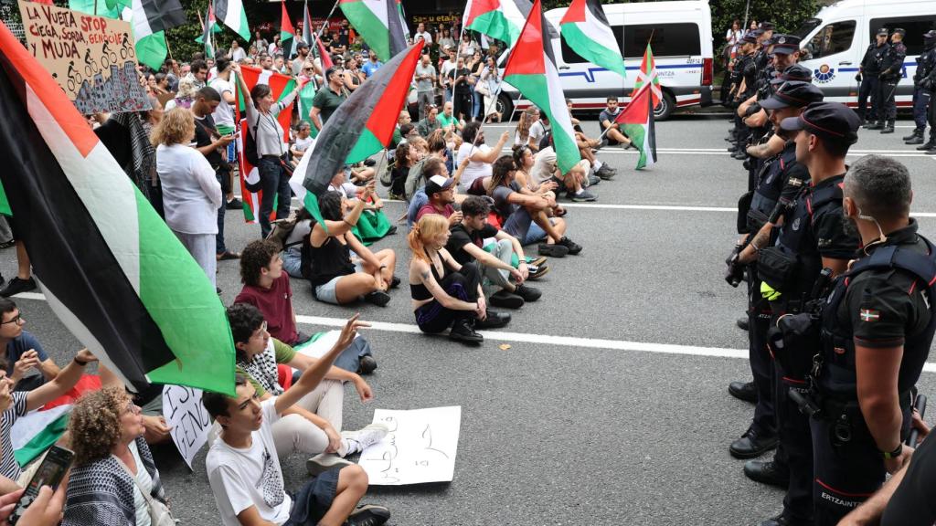 Agentes de la Ertzaintza vigilan a varios manifestantes propalestinos durante una etapa de La Vuelta.