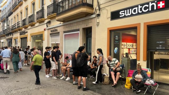 Las personas haciendo cola en la puerta de la tienda Swatch