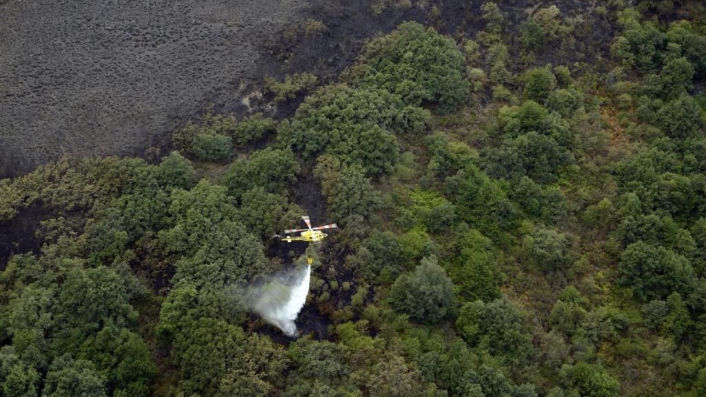 Un helicóptero trabaja en las labores de extinción del incendio en en Carballeda de Valdeorras (Ourense, Galicia)