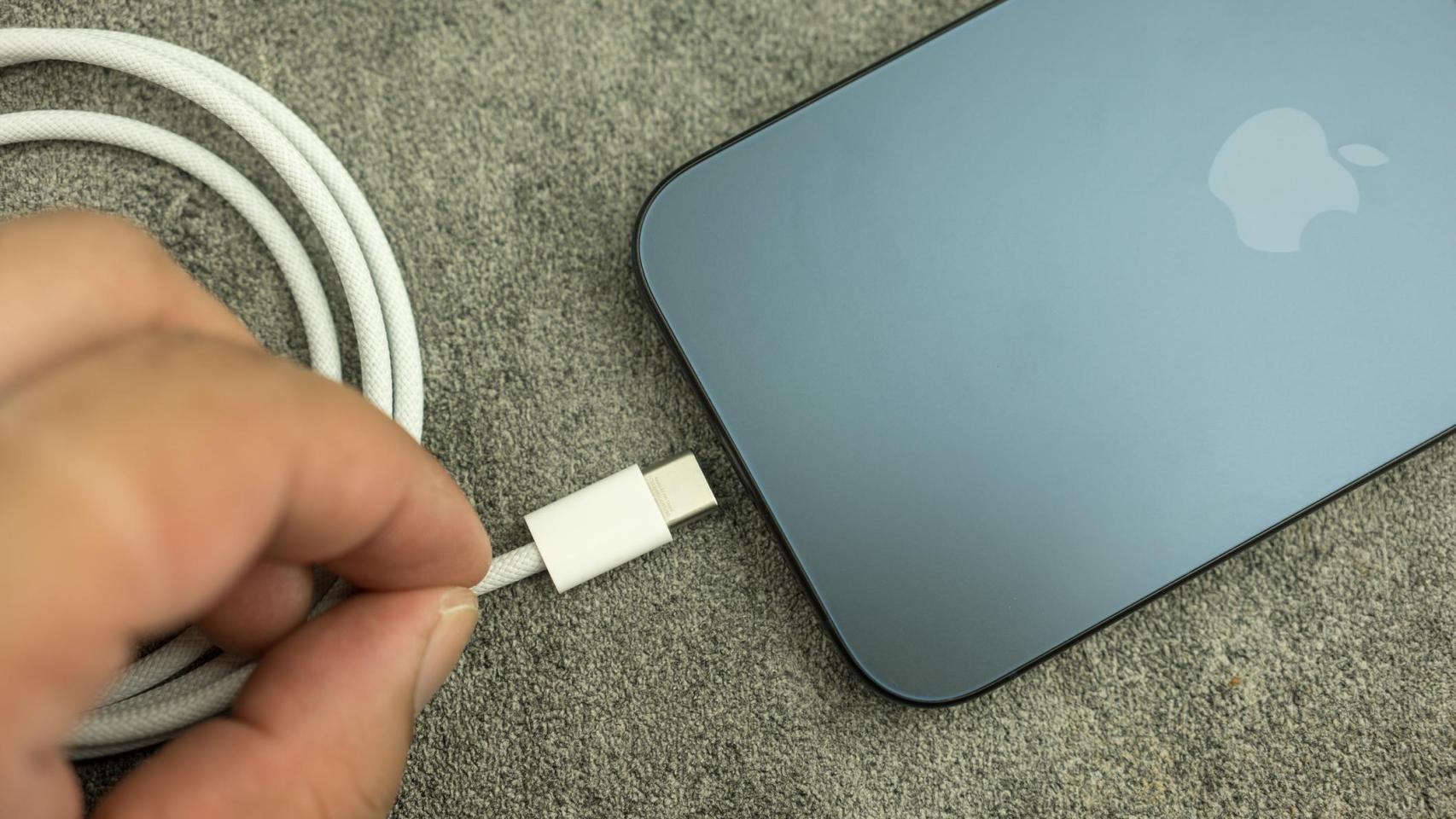 Imagen de una persona cargando la batería de un iPhone.