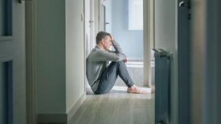 Imagen de un hombre sentado en el suelo.