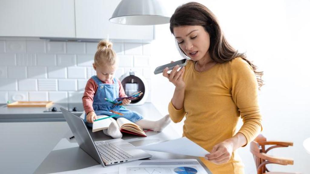 Madre trabajando con su bebé al lado.