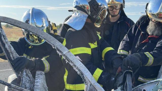 Los bomberos manipulando el coche accidentado en la M-410.
