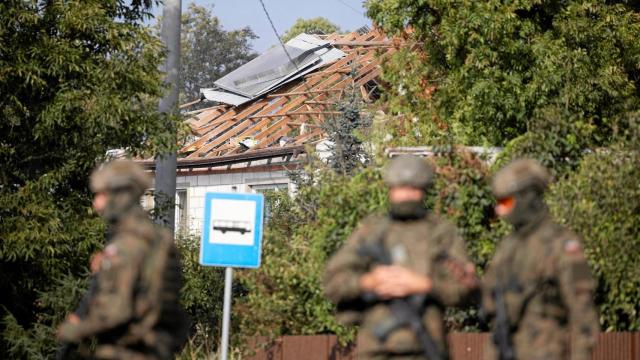 Militares delante de una casa en el pueblo de Wyryki alcanzada por el misil polaco.