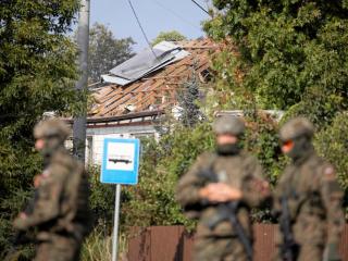 Soldados polacos delante de una casa en el pueblo de Wyryki alcanzada por un dron ruso.