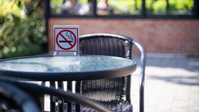 Una mesa en una terraza con el letrero de 'Prohibido fumar'.