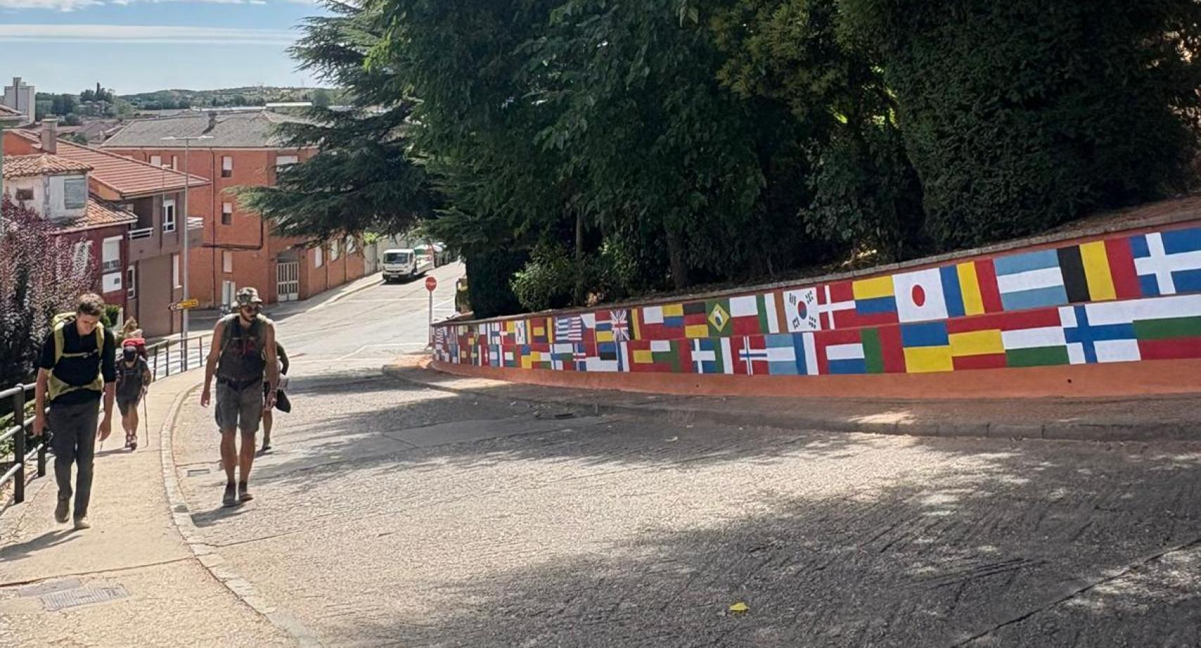 Un grupo de peregrinos recorre el nuevo mural que da la bienvenida a Astorga y simboliza el espíritu internacional del Camino