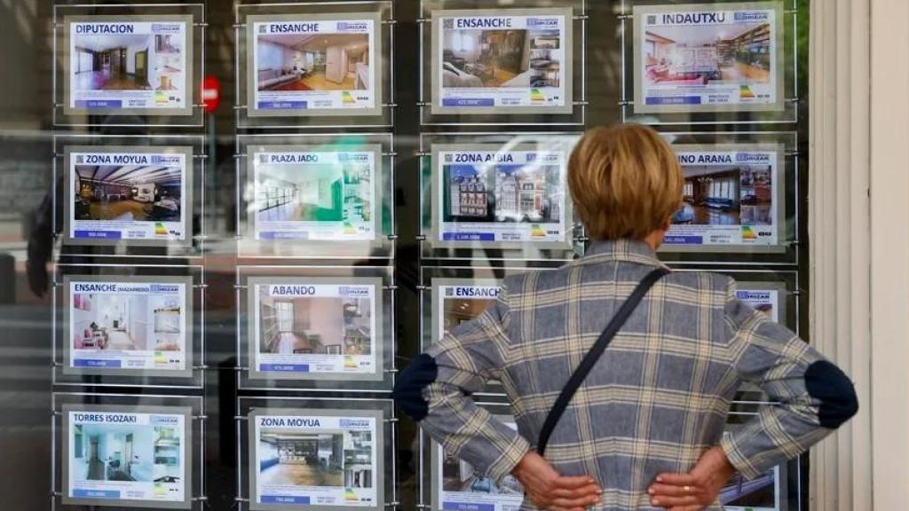 Una mujer mira la oferta de viviendas en una inmobiliaria en Bilbao.