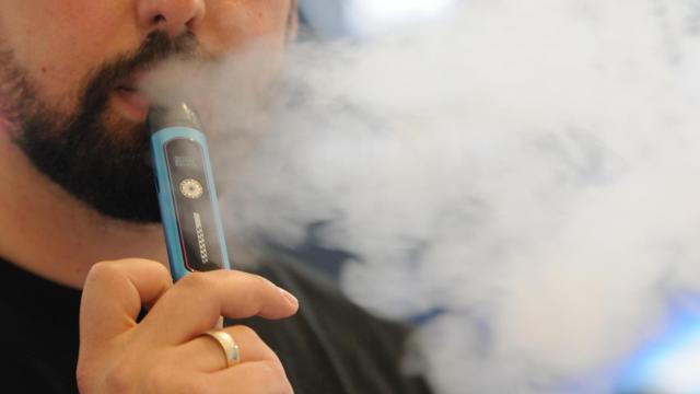 Un hombre consume un vaper.