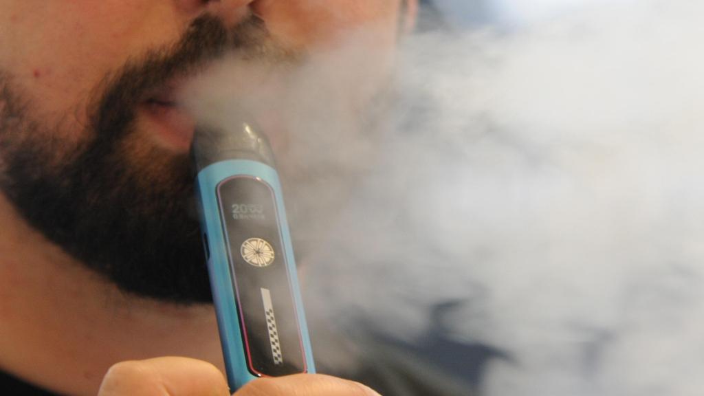 Un hombre consume un vaper.