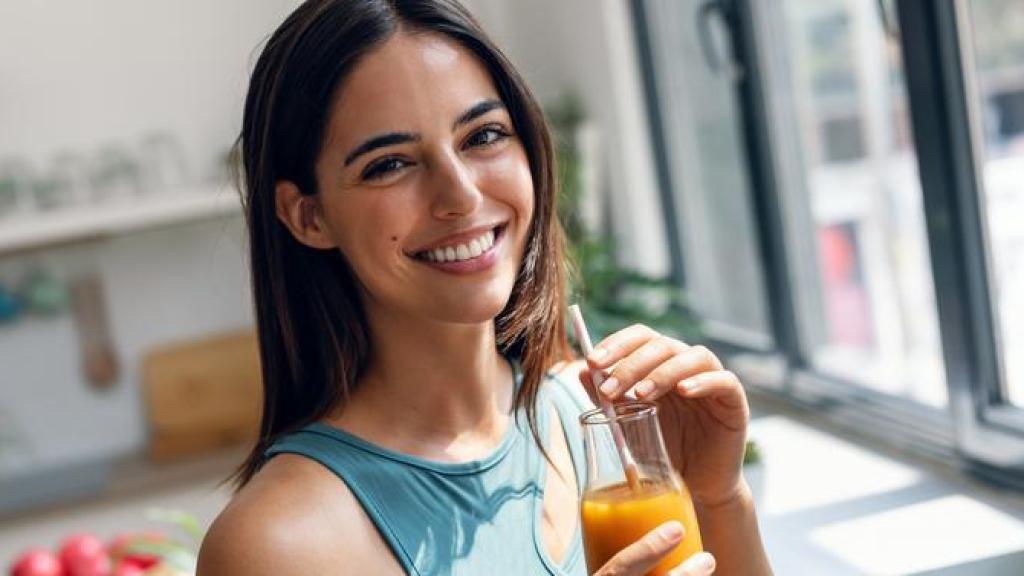 Mujer joven bebiendo zumo.