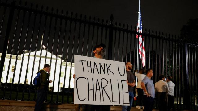 Un hombre sostiene un cartel de agradecimiento a Charlie Kirk frente a la Casa Blanca.