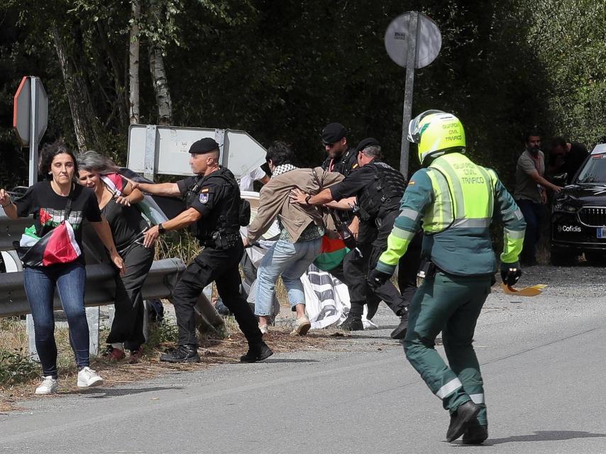 Activistas propalestinos boicotean la etapa de La Vuelta ciclista a su paso por Lugo, mientras los agentes tratan de impedirlo.