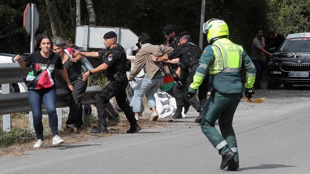 Activistas propalestinos boicotean la etapa de La Vuelta ciclista a su paso por Lugo, mientras los agentes tratan de impedirlo.