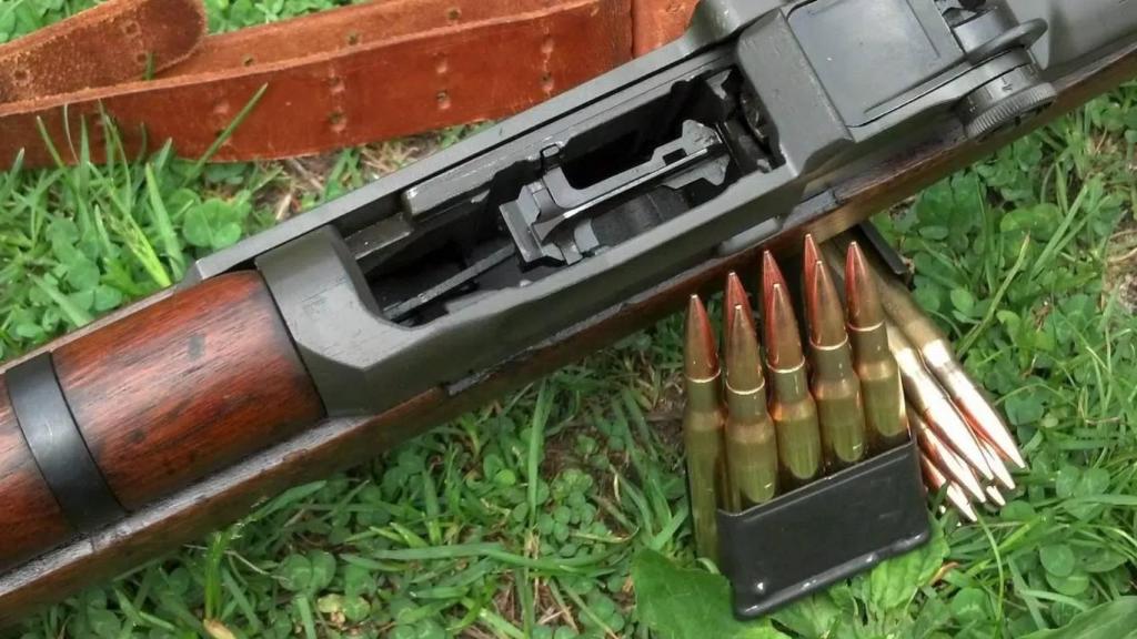 Munición .30-06 Springfield junto a un rifle.