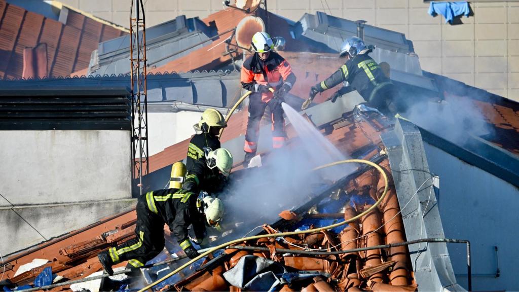 Unos bomberos apagando un incendio en una casa en Santander.