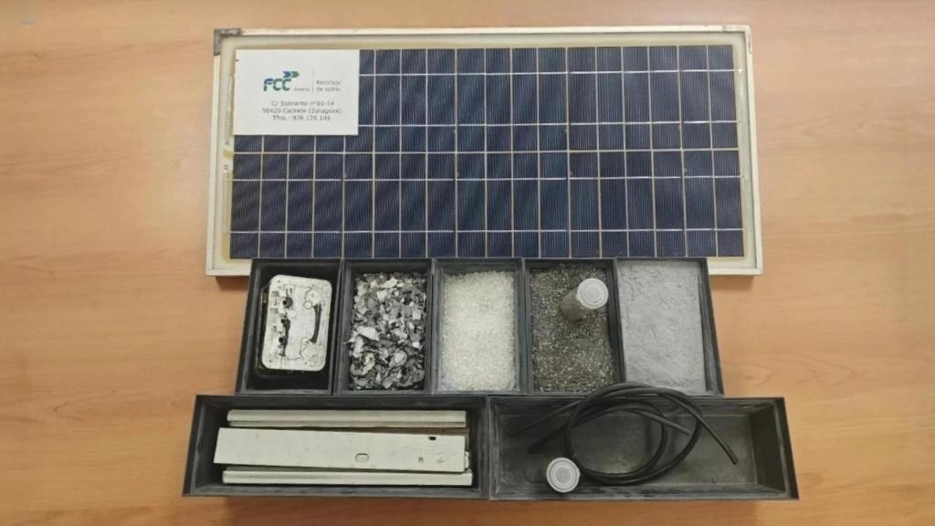 Un panel solar junto a los materiales para su reciclaje después del tratamiento en la planta de Cadrete (Zaragoza).