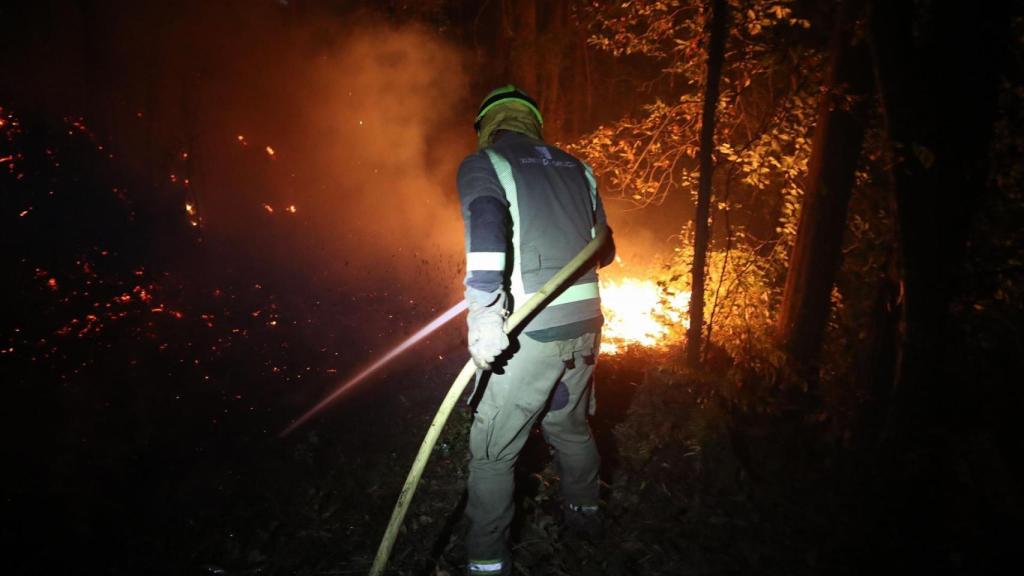 Un bomberos en las labores de extinción de un incendio en Barreiros