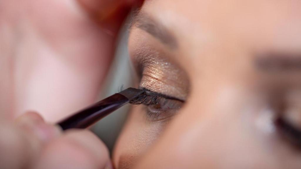 Imagen de una mujer pintándose los ojos.