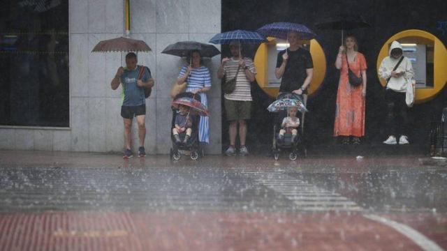 Varias personas resguardadas de la lluvia en Valencia. EFE/JC Cárdenas
