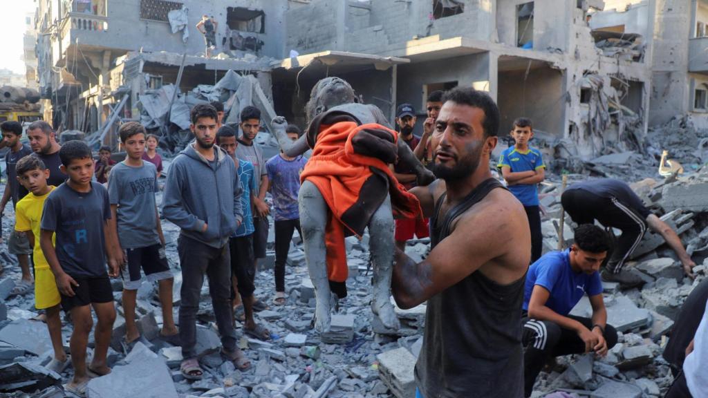Un hombre sostiene el cadáver de una niña asesinada por un ataque israelí en Ciudad de Gaza.