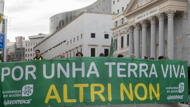 Archivo - Decenas de personas tras una pancarta en una concentración contra la multinacional Altri frente al Congreso de los Diputados